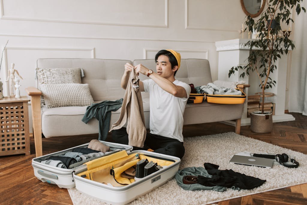 A Man Packing Clothes in a Suitcase